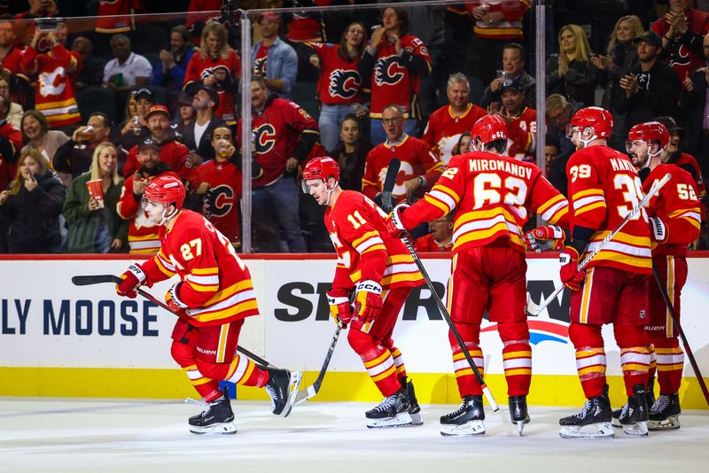 Oct 15, 2024; Calgary, Alberta, CAN; Calgary Flames right wing Matt Coronato (27) celebrates his goal with teammates against the Chicago Blackhawks during the third period at Scotiabank Saddledome. Mandatory Credit: Sergei Belski-Imagn Images