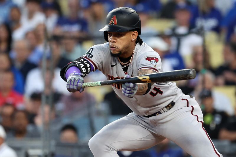 Oct 9, 2023; Los Angeles, California, USA; Arizona Diamondbacks second baseman Ketel Marte (4) hits a bunt against the Los Angeles Dodgers during the first inning for game two of the NLDS for the 2023 MLB playoffs at Dodger Stadium. Mandatory Credit: Kiyoshi Mio-USA TODAY Sports