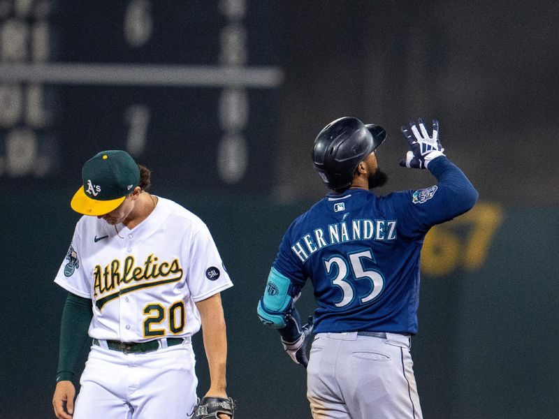 Sep 19, 2023; Oakland, California, USA; Seattle Mariners right fielder Teoscar Hernandez (35) celebrates at second base with Oakland Athletics second baseman Zack Gelof (20) looking away during the seventh inning at Oakland-Alameda County Coliseum. Mandatory Credit: Neville E. Guard-USA TODAY Sports