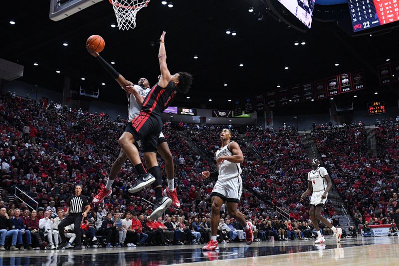 Jan 6, 2024; San Diego, California, USA; San Diego State Aztecs guard Micah Parrish (3) is fouled while going to the basket against UNLV Rebels forward Jalen Hill (1) during the first half at Viejas Arena. Mandatory Credit: Orlando Ramirez-USA TODAY Sports