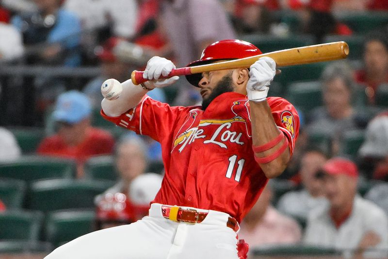 Jun 6, 2025; St. Louis, Missouri, USA;  St. Louis Cardinals center fielder Victor Scott II (11) avoids getting hit as he lays down a sacrifice bunt against the Los Angeles Dodgers during the fifth inning at Busch Stadium. Mandatory Credit: Jeff Curry-Imagn Images