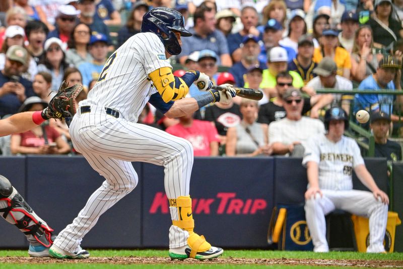 Jun 16, 2024; Milwaukee, Wisconsin, USA; Milwaukee Brewers  designated hitter Christian Yelich (22) drives in a run with a bunt single against the Cincinnati Reds in the seventh inning at American Family Field. Mandatory Credit: Benny Sieu-USA TODAY Sports