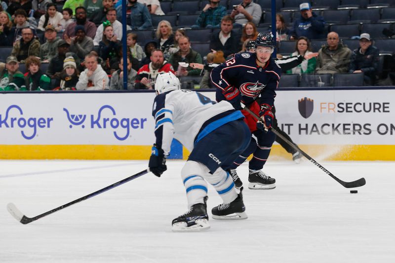 Mar 17, 2024; Columbus, Ohio, USA; Columbus Blue Jackets center Alexander Texier (42) looks to pass as Winnipeg Jets defenseman Neal Pionk (4) defends during the second period at Nationwide Arena. Mandatory Credit: Russell LaBounty-USA TODAY Sports