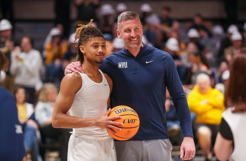 Mar 2, 2024; Morgantown, West Virginia, USA; West Virginia Mountaineers head coach Josh Eilert honors West Virginia Mountaineers guard Noah Farrakhan (1) before the game for scoring his 1,000th point earlier this week at WVU Coliseum. Mandatory Credit: Ben Queen-USA TODAY Sports