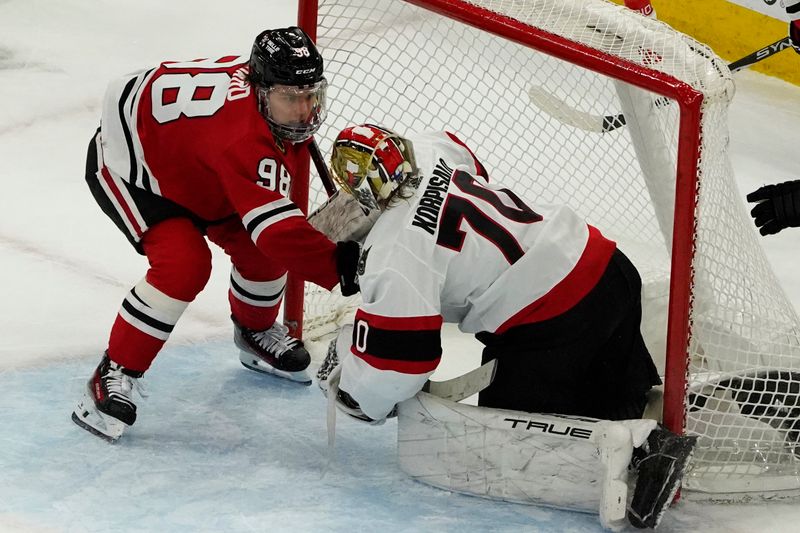 Feb 17, 2024; Chicago, Illinois, USA; Chicago Blackhawks center Connor Bedard (98) and Ottawa Senators goaltender Joonas Korpisalo (70) get close in the goal during the second period at United Center. Mandatory Credit: David Banks-USA TODAY Sports