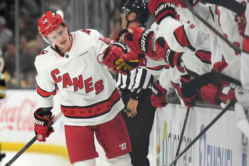 Apr 9, 2024; Boston, Massachusetts, USA; Carolina Hurricanes center Jake Guentzel (59) is congratulated by his teammates after scoring a goal during the third period against the Boston Bruins at TD Garden. Mandatory Credit: Bob DeChiara-USA TODAY Sports