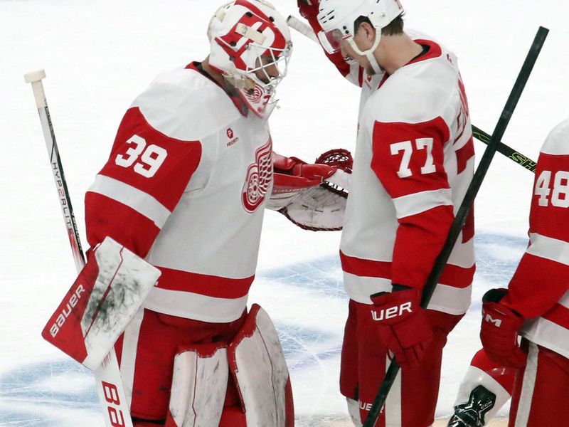 Nov 13, 2024; Pittsburgh, Pennsylvania, USA;  Detroit Red Wings goaltender Cam Talbot (39) and defenseman Simon Edvinsson (77) celebrate after defeating the Pittsburgh Penguins in overtime at PPG Paints Arena. Mandatory Credit: Charles LeClaire-Imagn Images