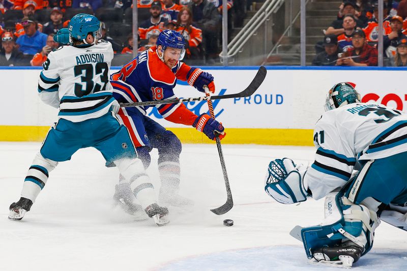 Apr 15, 2024; Edmonton, Alberta, CAN; Edmonton Oilers forward Zach Hyman (18) tries to get a shot away on San Jose Sharks goaltender Georgi Romanov (31) during the third period at Rogers Place. Mandatory Credit: Perry Nelson-USA TODAY Sports