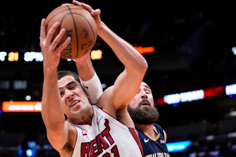 MIAMI, FLORIDA - MARCH 22: Cole Swider #21 of the Miami Heat and Jonas Valanciunas #17 of the New Orleans Pelicans compete for a rebound during the fourth quarter at Kaseya Center on March 22, 2024 in Miami, Florida. NOTE TO USER: User expressly acknowledges and agrees that, by downloading and or using this photograph, User is consenting to the terms and conditions of the Getty Images License Agreement. (Photo by Rich Storry/Getty Images)