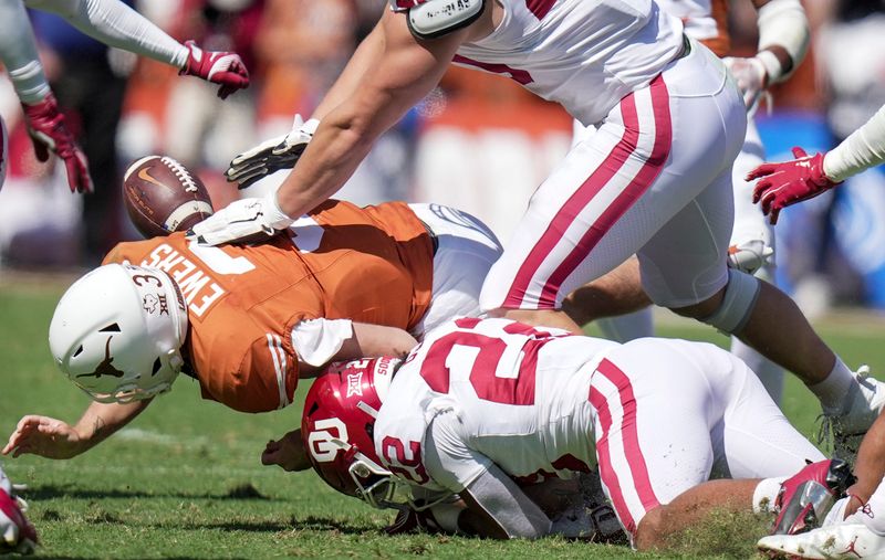 Oct 7, 2023; Dallas, Texas, USA; Texas Longhorns quarterback Quinn Ewers (3) fumbles the ball against Oklahoma Sooners defensive lineman Ethan Downs (40) in the third quarter at the Cotton Bowl. This game makes up the 119th rivalry match up. Mandatory Credit: Ricardo B. Brazziell-USA TODAY Sports