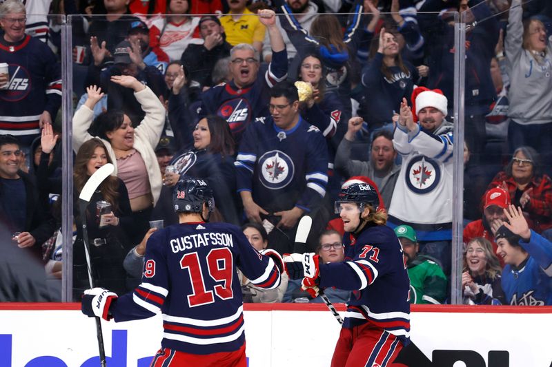 Dec 20, 2023; Winnipeg, Manitoba, CAN;Winnipeg Jets left wing Axel Jonsson-Fjallby (71) celebrates his second period goal with Winnipeg Jets center David Gustafsson (19) against the Detroit Red Wings at Canada Life Centre. Mandatory Credit: James Carey Lauder-USA TODAY Sports