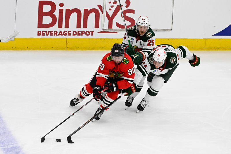 Apr 7, 2024; Chicago, Illinois, USA;  Chicago Blackhawks center Tyler Johnson (90) moves the puck away from Minnesota Wild defenseman Jonas Brodin (25) and center Joel Eriksson Ek (14) during the second period at United Center. Mandatory Credit: Matt Marton-USA TODAY Sports