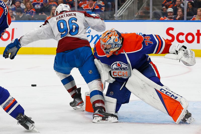 Mar 16, 2024; Edmonton, Alberta, CAN; Edmonton Oilers goaltender Stuart Skinner (74) throws a shoulder into Colorado Avalanche forward Mikko Rantanen (96) during the second period at Rogers Place. Mandatory Credit: Perry Nelson-USA TODAY Sports