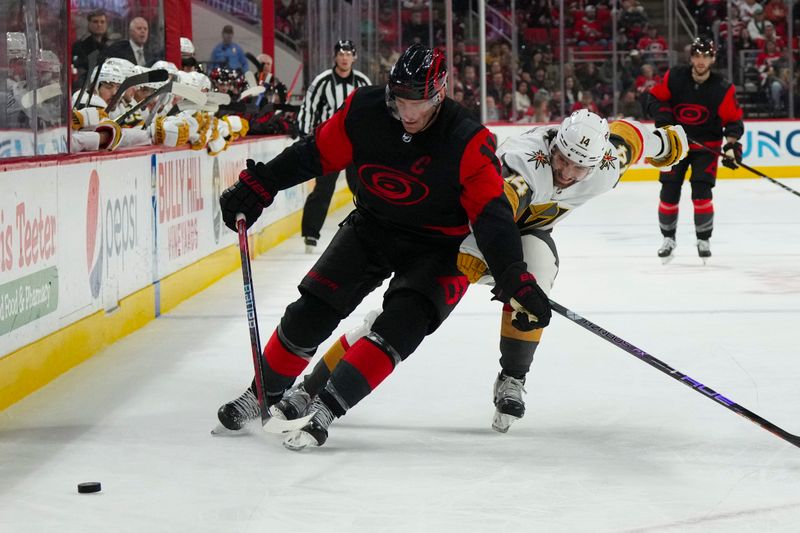 Mar 11, 2023; Raleigh, North Carolina, USA; Carolina Hurricanes center Jordan Staal (11) skates with the puck past Vegas Golden Knights defenseman Nicolas Hague (14) during the third period at PNC Arena. Mandatory Credit: James Guillory-USA TODAY Sports