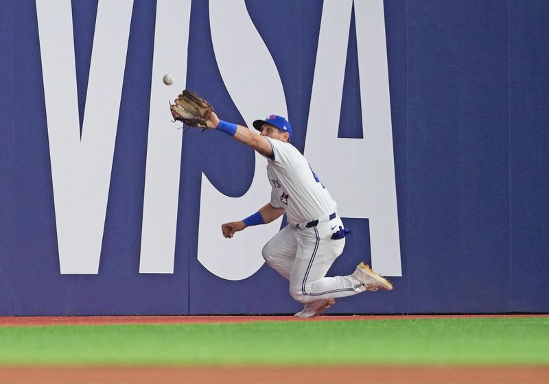 Apr 15, 2024; Toronto, Ontario, CAN; Toronto Blue Jays outfielder Daulton Varsho wearing number 42 for Jackie Robinson Day catches a fly ball for an out against the New York Yankees during the seventh inning at Rogers Centre. Mandatory Credit: Nick Turchiaro-USA TODAY Sports