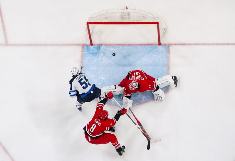 Mar 2, 2024; Raleigh, North Carolina, USA; Winnipeg Jets center Mark Scheifele (55) scores a goal past Carolina Hurricanes goaltender Pyotr Kochetkov (52) during the third period at PNC Arena. Mandatory Credit: James Guillory-USA TODAY Sports