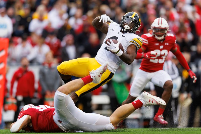 Oct 14, 2023; Madison, Wisconsin, USA;  Iowa Hawkeyes running back Leshon Williams (4) is tackled by Wisconsin Badgers linebacker C.J. Goetz (98) during the second quarter at Camp Randall Stadium. Mandatory Credit: Jeff Hanisch-USA TODAY Sports