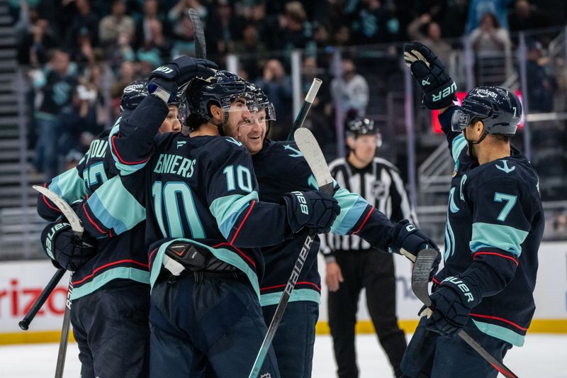 Oct 24, 2024; Seattle, Washington, USA;   Seattle Kraken, from left, defenseman Brandon Montour (62) forward Matty Beniers (10), forward Jared McCann (19) and forward Jordan Eberle (7) celebrate a goal during the third period against the Winnipeg Jetsat Climate Pledge Arena. Mandatory Credit: Stephen Brashear-Imagn Images