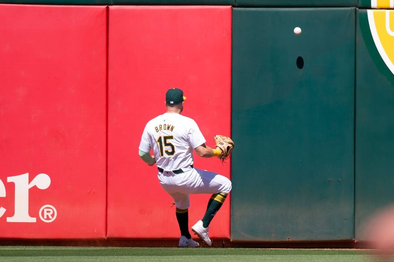 Sep 8, 2024; Oakland, California, USA; Oakland Athletics left fielder Seth Brown (15) plays a double by Detroit Tigers shortstop Trey Sweeney off the wall during the fourth inning at Oakland-Alameda County Coliseum. Mandatory Credit: D. Ross Cameron-Imagn Images