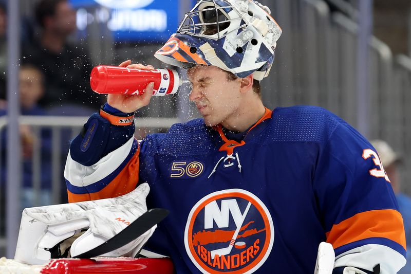 Nov 7, 2022; Elmont, New York, USA; New York Islanders goaltender Ilya Sorokin (30) sprays water on his face during the third period against the Calgary Flames at UBS Arena. Mandatory Credit: Brad Penner-USA TODAY Sports