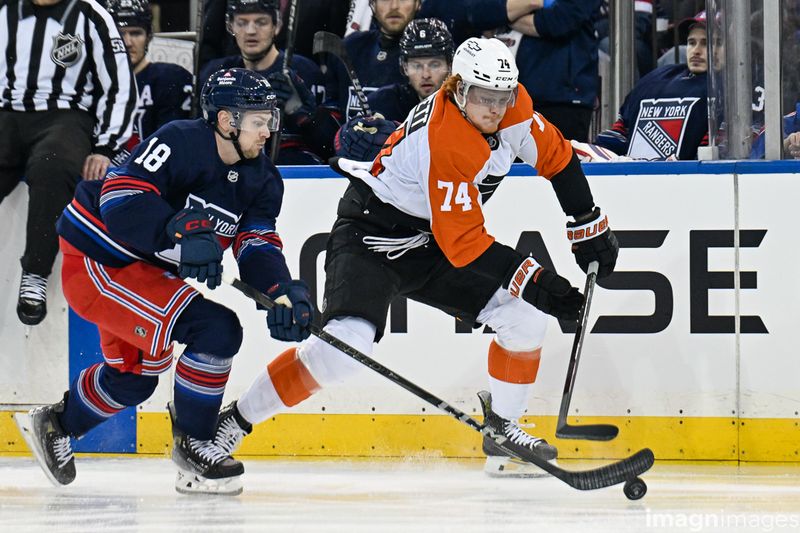 Apr 9, 2025; New York, New York, USA;  Philadelphia Flyers right wing Owen Tippett (74) and New York Rangers defenseman Urho Vaakanainen (18) battle for the puck during the first period at Madison Square Garden. Mandatory Credit: Dennis Schneidler-Imagn Images