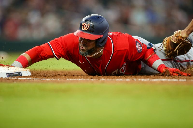 Apr 11, 2022; Atlanta, Georgia, USA; Washington Nationals designated hitter Nelson Cruz (23) slides safely ahead of the tag by Atlanta Braves first baseman Matt Olson (right) in the third inning at Truist Park. Mandatory Credit: Brett Davis-USA TODAY Sports