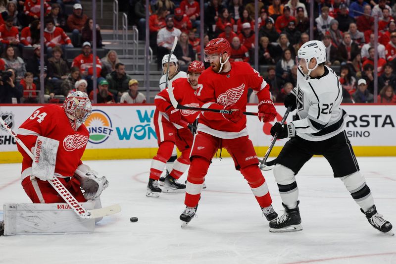 Jan 13, 2024; Detroit, Michigan, USA;  Detroit Red Wings goaltender Alex Lyon (34) makes a save in front of Detroit Red Wings left wing J.T. Compher (37) and Los Angeles Kings left wing Kevin Fiala (22) in the first period at Little Caesars Arena. Mandatory Credit: Rick Osentoski-USA TODAY Sports