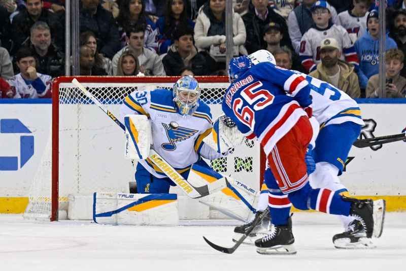 Nov 24, 2025; New York, New York, USA;  St. Louis Blues goaltender Joel Hofer (30) makes a save on a shoot by New York Rangers left wing Brett Berard (65) during the first period at Madison Square Garden. Mandatory Credit: Dennis Schneidler-Imagn Images