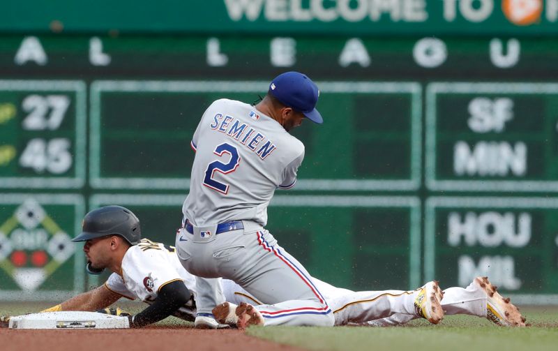 May 22, 2023; Pittsburgh, Pennsylvania, USA;  Pittsburgh Pirates shortstop Tucupita Marcano (30) steals second base as Texas Rangers second baseman Marcus Semien (2) applies a late tag during the fourth inning at PNC Park. Mandatory Credit: Charles LeClaire-USA TODAY Sports