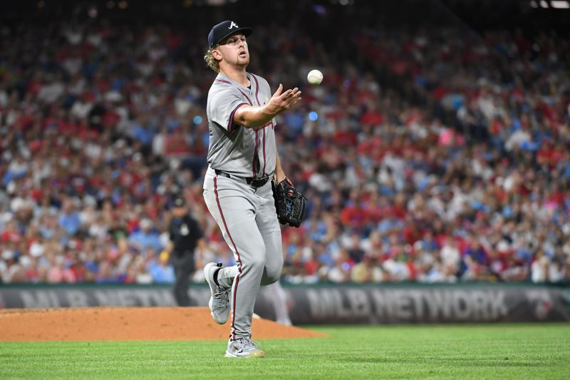 Sep 1, 2024; Philadelphia, Pennsylvania, USA; Atlanta Braves pitcher Spencer Schwellenbach (56) flips the ball to first base against the Philadelphia Phillies during the fifth inning at Citizens Bank Park. Mandatory Credit: Eric Hartline-USA TODAY Sports