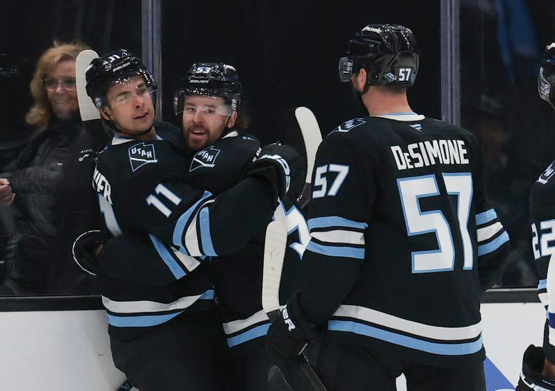 Jan 13, 2026; Salt Lake City, Utah, USA; Utah Mammoth right wing Dylan Guenther (11) celebrates scoring a goal with left wing Michael Carcone (53) and defenseman Nick DeSimone (57) during the second period against the Toronto Maple Leafs at Delta Center. Mandatory Credit: Rob Gray-Imagn Images