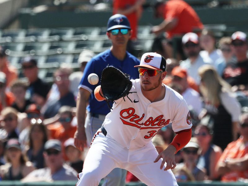 Feb 27, 2025; Sarasota, Florida, USA; Baltimore Orioles first base Ryan O'Hearn (32) catches the ball for an out against the Toronto Blue Jays during the first inning at Ed Smith Stadium. Mandatory Credit: Kim Klement Neitzel-Imagn Images