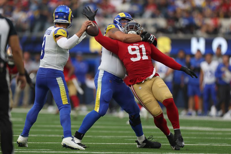 San Francisco 49ers defensive tackle Sam Okuayinonu (91) reaches for Los Angeles Rams quarterback Matthew Stafford, left, while being blocked by offensive tackle Rob Havenstein during the second half of an NFL football game, Sunday, Sept. 22, 2024, in Inglewood, Calif. (AP Photo/Ryan Sun)