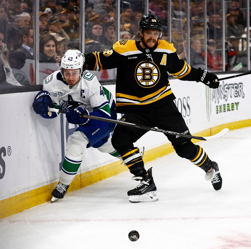 Nov 26, 2024; Boston, Massachusetts, USA; Vancouver Canucks defenseman Quinn Hughes (43) and Boston Bruins right wing David Pastrnak (88) eye a loose puck during the third period at TD Garden. Mandatory Credit: Winslow Townson-Imagn Images