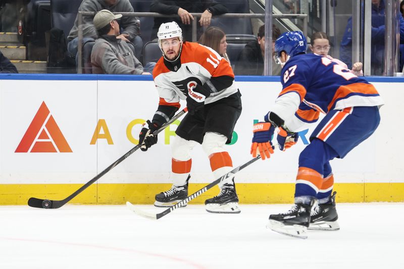 Jan 16, 2025; Elmont, New York, USA;  Philadelphia Flyers right wing Travis Konecny (11) looks to make a pass while defended by New York Islanders left wing Anders Lee (27) in the first period at UBS Arena. Mandatory Credit: Wendell Cruz-Imagn Images