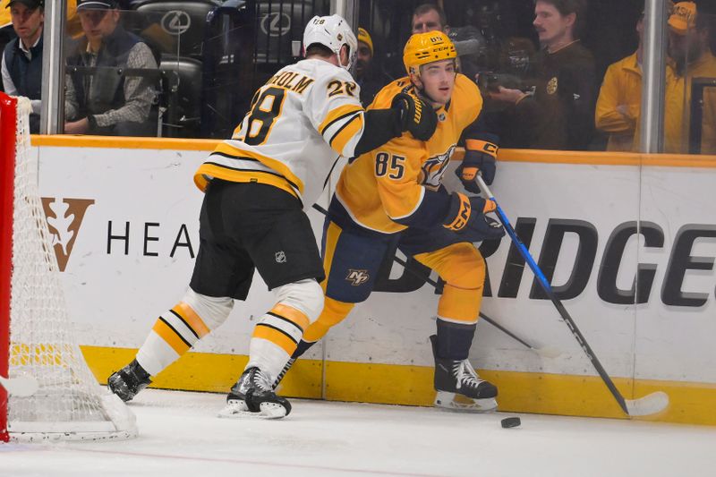 Mar 5, 2026; Nashville, Tennessee, USA;  Nashville Predators defenseman Ryan Ufko (85) takes a glove to the face from Boston Bruins center Elias Lindholm (28) during the second period at Bridgestone Arena. Mandatory Credit: Steve Roberts-Imagn Images
