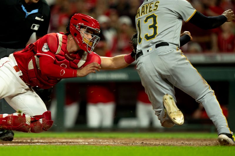 Sep 23, 2023; Cincinnati, Ohio, USA; Cincinnati Reds catcher Tyler Stephenson (37) tags out Pittsburgh Pirates third baseman Ke'Bryan Hayes (13) in the eighth inning at Great American Ball Park. Mandatory Credit: The Cincinnati Enquirer-USA TODAY Sports