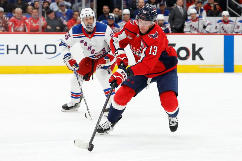 Oct 29, 2024; Washington, District of Columbia, USA; Washington Capitals left wing Jakub Vrana (13) skates with the puck as New York Rangers defenseman Ryan Lindgren (55) chases in the first period at Capital One Arena. Mandatory Credit: Geoff Burke-Imagn Images