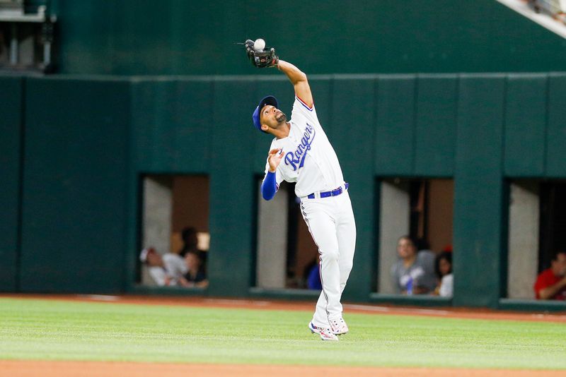 May 15, 2023; Arlington, Texas, USA; Texas Rangers second baseman Marcus Semien (2) reaches back to catch a fly ball during the seventh inning against the Atlanta Braves at Globe Life Field. Mandatory Credit: Andrew Dieb-USA TODAY Sports