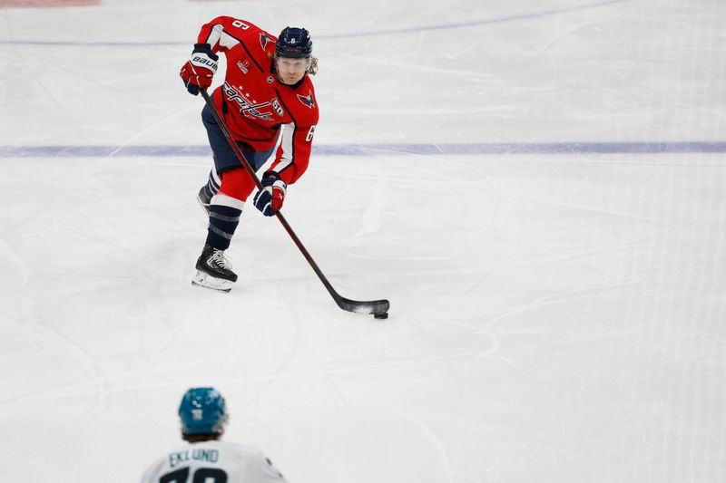 Dec 3, 2024; Washington, District of Columbia, USA; Washington Capitals defenseman Jakob Chychrun (6) shoots the puck as San Jose Sharks left wing William Eklund (72) defends in the first period at Capital One Arena. Mandatory Credit: Geoff Burke-Imagn Images