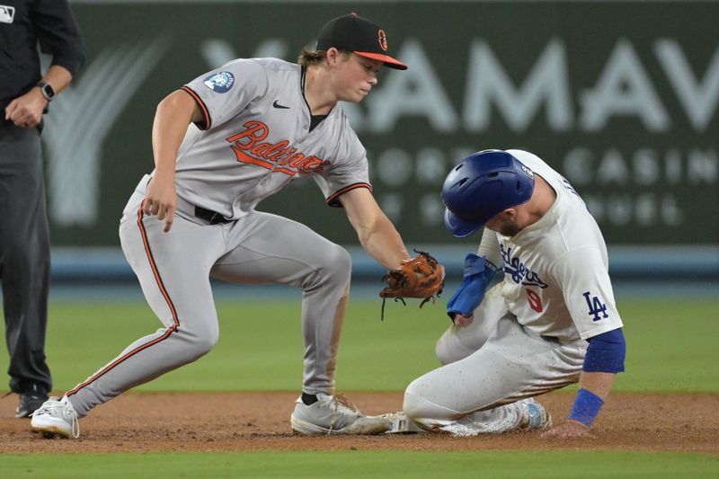 Aug 28, 2024; Los Angeles, California, USA;  Los Angeles Dodgers second baseman Gavin Lux (9) beats the tag by Baltimore Orioles second baseman Jackson Holliday (7) for a stolen base in the fifth inning at Dodger Stadium. Mandatory Credit: Jayne Kamin-Oncea-USA TODAY Sports