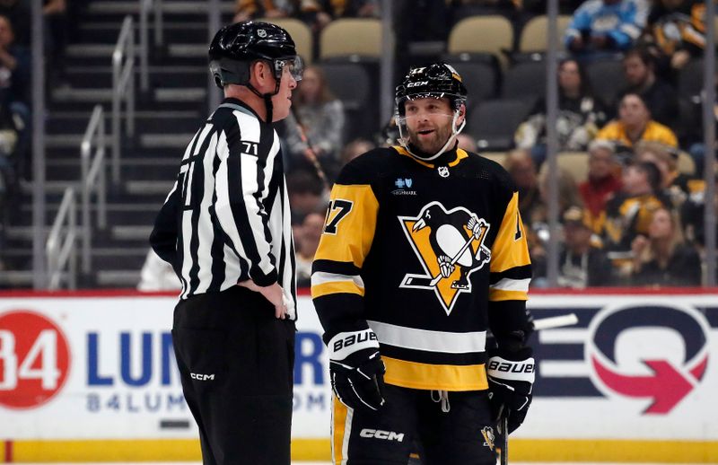 Apr 15, 2024; Pittsburgh, Pennsylvania, USA;  NHL linesman Brad Kovachik (71) talks with Pittsburgh Penguins right wing Bryan Rust (17) against the Nashville Predators during the first period at PPG Paints Arena. The Penguins won 4-2. Mandatory Credit: Charles LeClaire-USA TODAY Sports