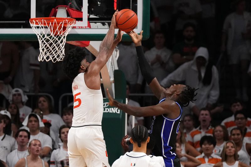 Feb 6, 2023; Coral Gables, Florida, USA; Miami Hurricanes forward Norchad Omier (15) blocks the shot of Duke Blue Devils forward Mark Mitchell (25) during the second half at Watsco Center. Mandatory Credit: Jasen Vinlove-USA TODAY Sports