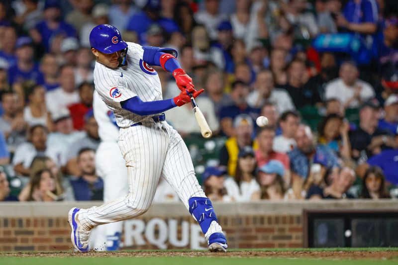 May 21, 2024; Chicago, Illinois, USA; Chicago Cubs catcher Miguel Amaya (9) singles against the Atlanta Braves during the sixth inning at Wrigley Field. Mandatory Credit: Kamil Krzaczynski-USA TODAY Sports