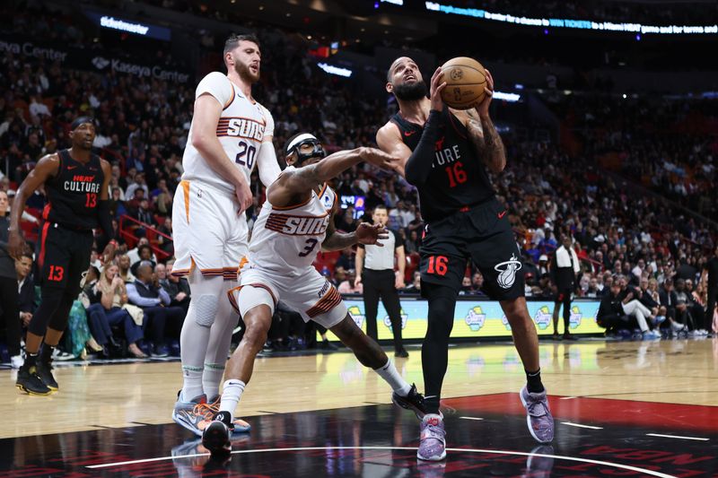 MIAMI, FLORIDA - JANUARY 29: Caleb Martin #16 of the Miami Heat drives to the basket past Bradley Beal #3 of the Phoenix Suns during the fourth quarter of the game at Kaseya Center on January 29, 2024 in Miami, Florida. NOTE TO USER: User expressly acknowledges and agrees that, by downloading and or using this photograph, User is consenting to the terms and conditions of the Getty Images License Agreement. (Photo by Megan Briggs/Getty Images)