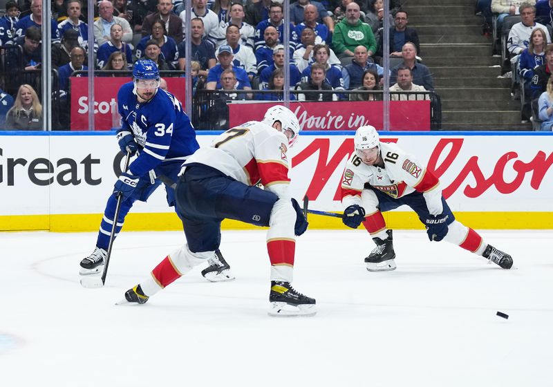 May 7, 2025; Toronto, Ontario, CAN; Toronto Maple Leafs center Auston Matthews (34) battles for the puck with Florida Panthers center Aleksander Barkov (16) during the third period in game two of the second round of the 2025 Stanley Cup Playoffs at Scotiabank Arena. Mandatory Credit: Nick Turchiaro-Imagn Images
