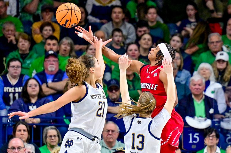 Mar 3, 2024; South Bend, Indiana, USA; Louisville Cardinals guard Nina Rickards (15) goes up for a shot as Notre Dame Fighting Irish forward Maddy Westbeld (21) and guard Anna Dewolfe (13) defend in the second half at the Purcell Pavilion. Mandatory Credit: Matt Cashore-USA TODAY Sports