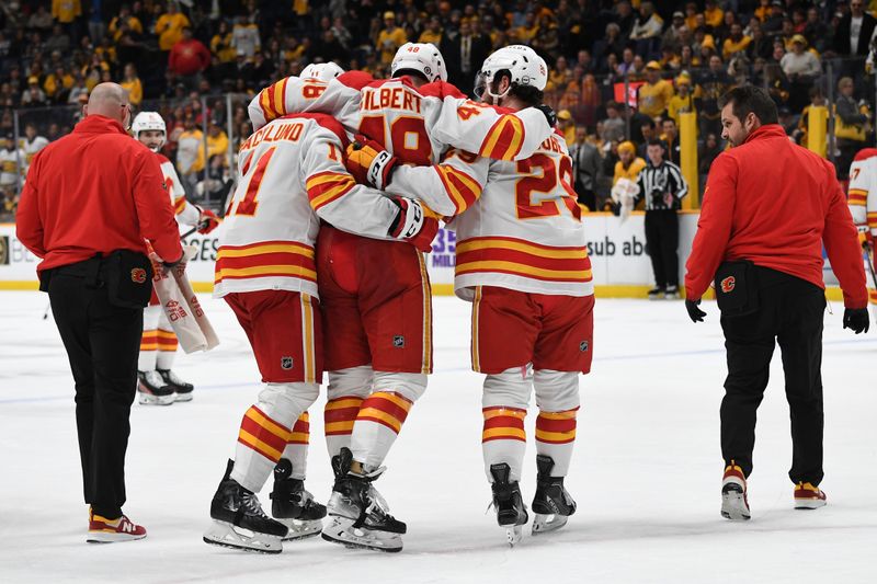 Jan 4, 2024; Nashville, Tennessee, USA; Calgary Flames defenseman Dennis Gilbert (48) is helped off the ice by center Mikael Backlund (11) and center Dillon Dube (29) after an injury during the third period against the Nashville Predators at Bridgestone Arena. Mandatory Credit: Christopher Hanewinckel-USA TODAY Sports