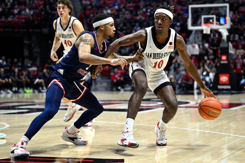 Jan 3, 2024; San Diego, California, USA; San Diego State Aztecs guard BJ Davis (10) dribbles the ball while defended by Fresno State Bulldogs guard Isaiah Hill (3) during the second half at Viejas Arena. Mandatory Credit: Orlando Ramirez-USA TODAY Sports 