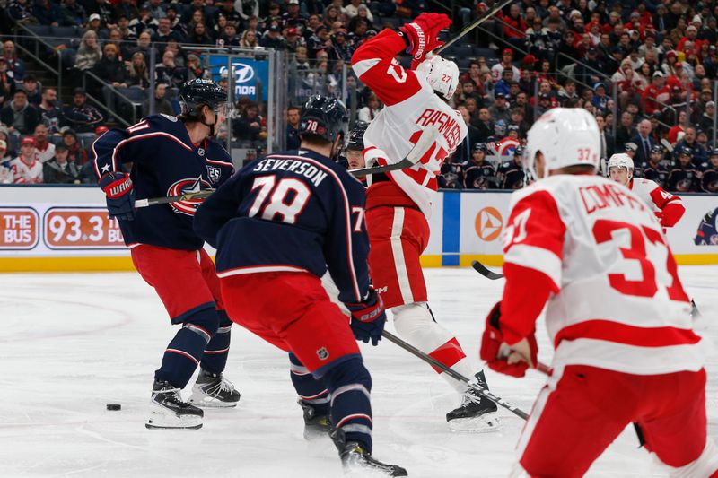 Dec 4, 2025; Columbus, Ohio, USA; Detroit Red Wings center Michael Rasmussen (27) avoids a Red Wing shot as Columbus Blue Jackets left wing Miles Wood (11) defends during the first period at Nationwide Arena. Mandatory Credit: Russell LaBounty-Imagn Images